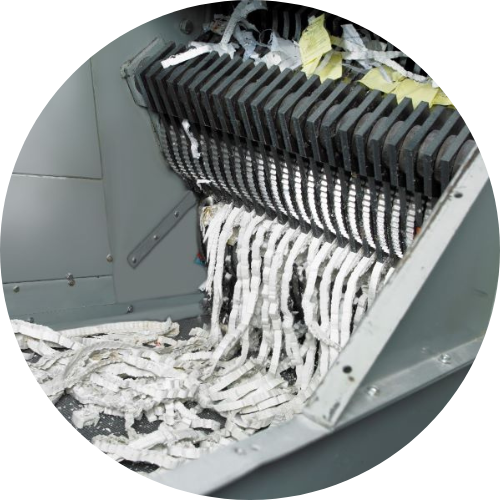 Close up image of strips of paper coming out of an industrial shredder